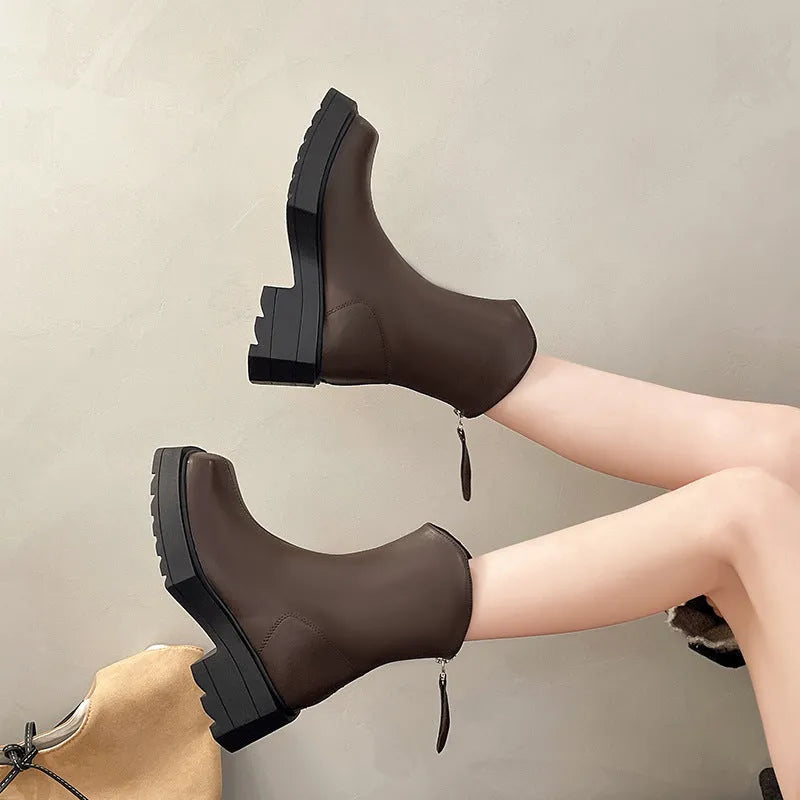 Women's black platform Martin boots with square toe, chunky heel, and back zipper on a plain background