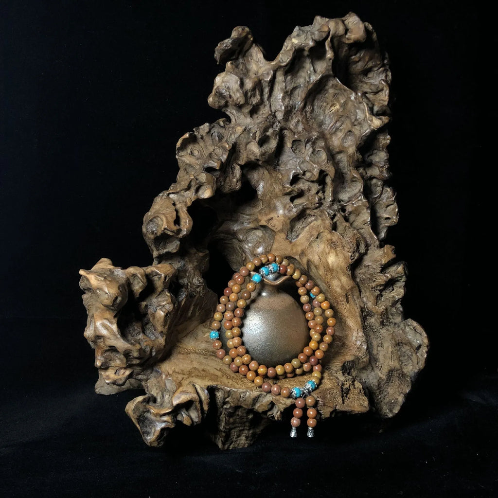 Handmade stone bead bracelet with 108 round geometric beads on a wrist.