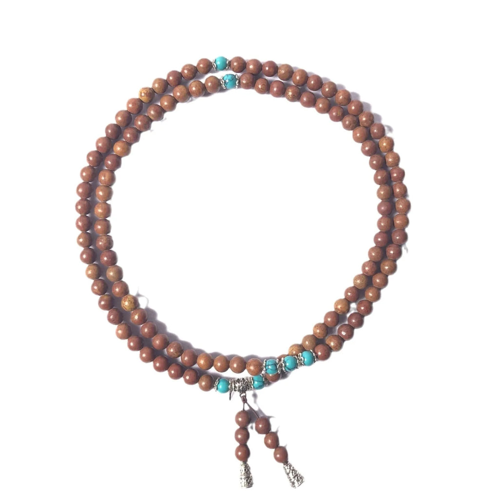 Handmade stone bead bracelet with 108 round geometric beads on a wrist.