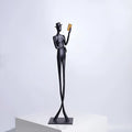 Black cast aluminium desktop sculpture of reading woman figure measuring 12x51cm in modern minimalist style.