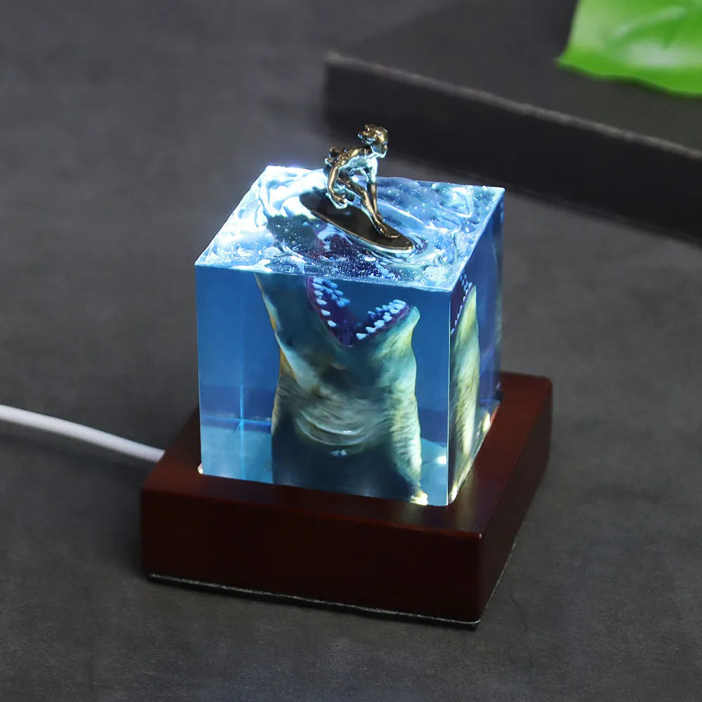 Clear epoxy resin ornament with shark surfer scene inside, shown next to a scale indicating 5cm and 8cm size options.