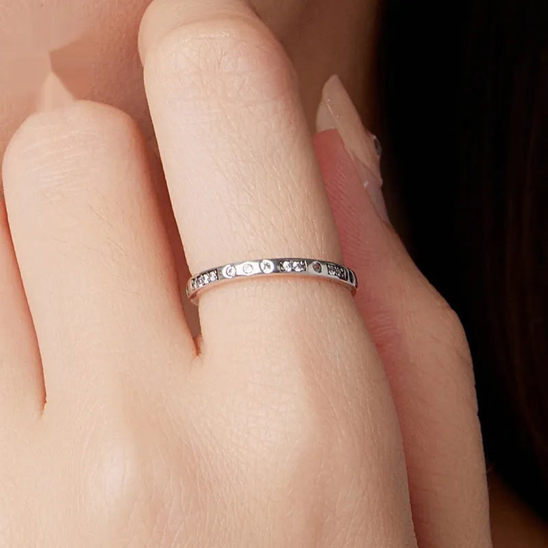Sterling silver I Love You ring with oxidised black finish and moss knot design on a finger.