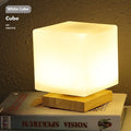 Nordic solid wood flower-shaped USB table lamp with touch dimming in a white cube style on a table