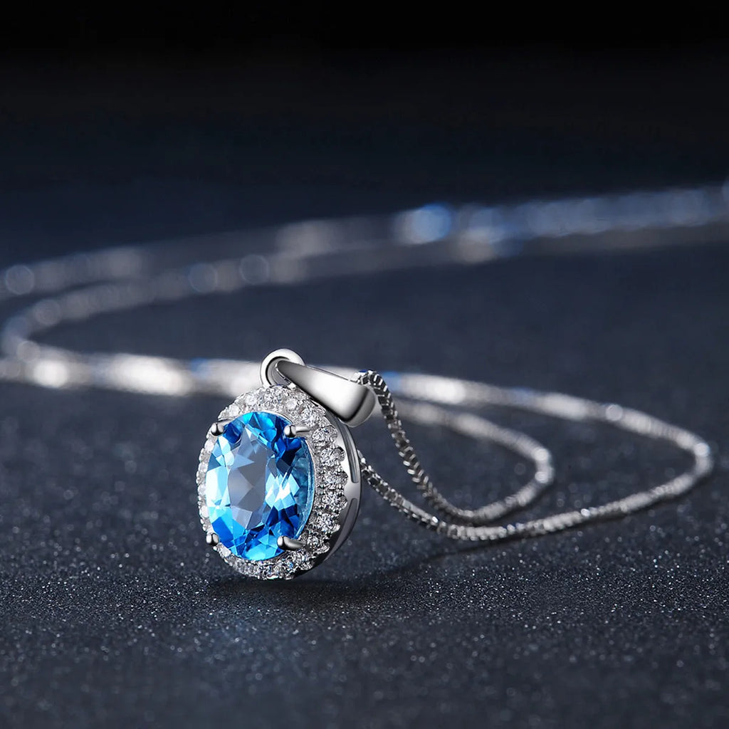 925 sterling silver geometric jewellery set with blue topaz gemstones, showing earrings, ring, pendant, and necklace.