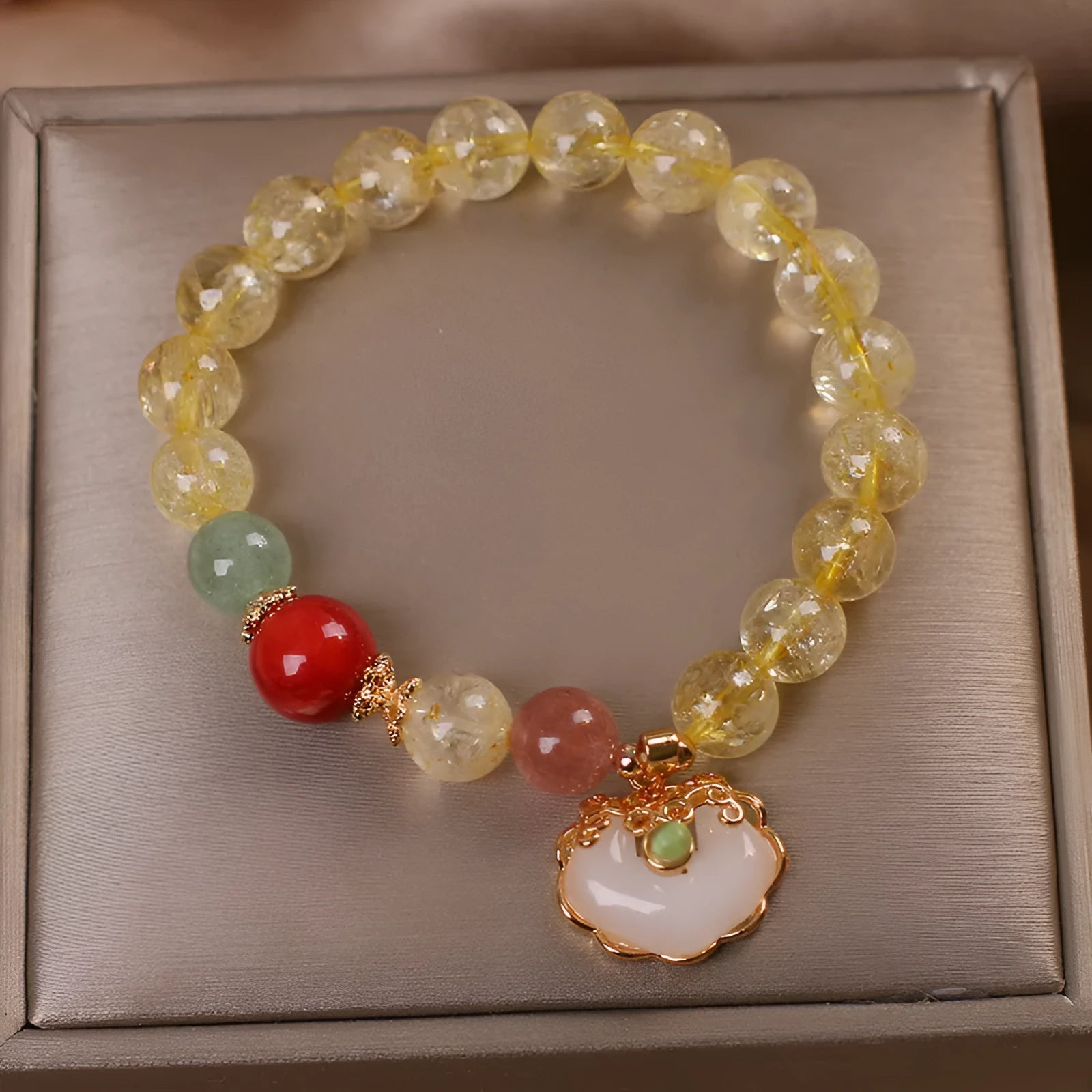 Yellow citrine jade ruyi pendant on an alloy women's bracelet.
