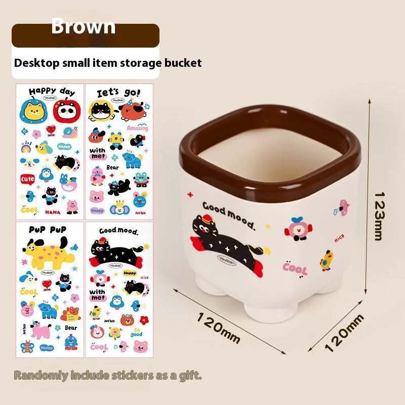 Cartoon-style plastic desktop organiser with grid compartments and labelling stickers for stationery storage