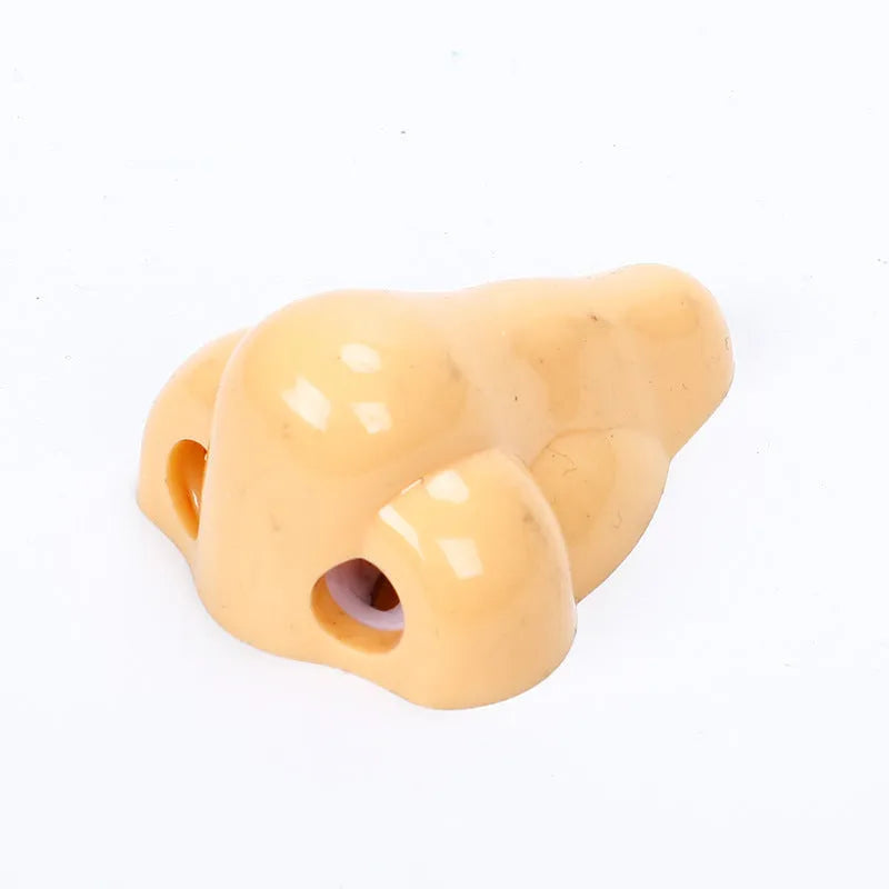 Flesh coloured geometry-shaped plastic manual pencil sharpener on a white background.