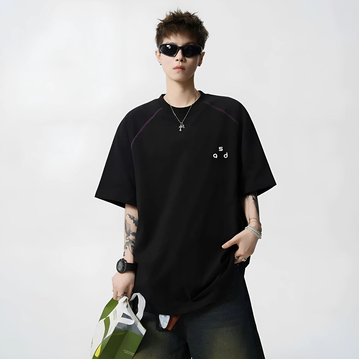 Loose-fitting black cotton T-shirt with a letter print on the chest, showing short sleeves and a round neck.