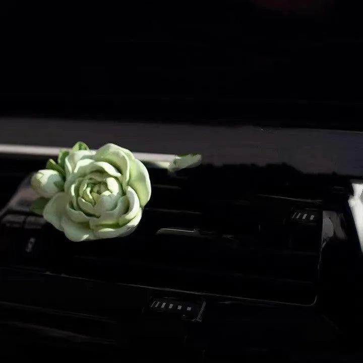 Jasmine scented gypsum solid car perfume clipped to a car air vent in off white or fresh green.