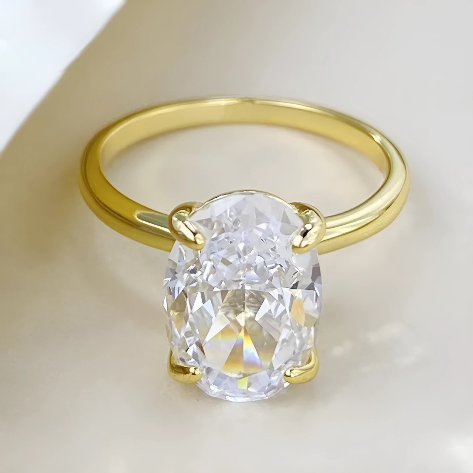 Oval women's ring with four-claw setting holding a 6x9mm gemstone on a silver band