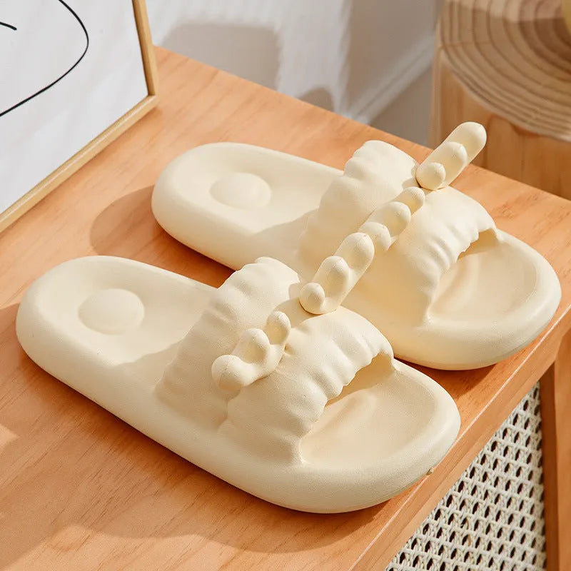 Pair of light-coloured EVA flip flop slippers with hollow-out design and textured sole.