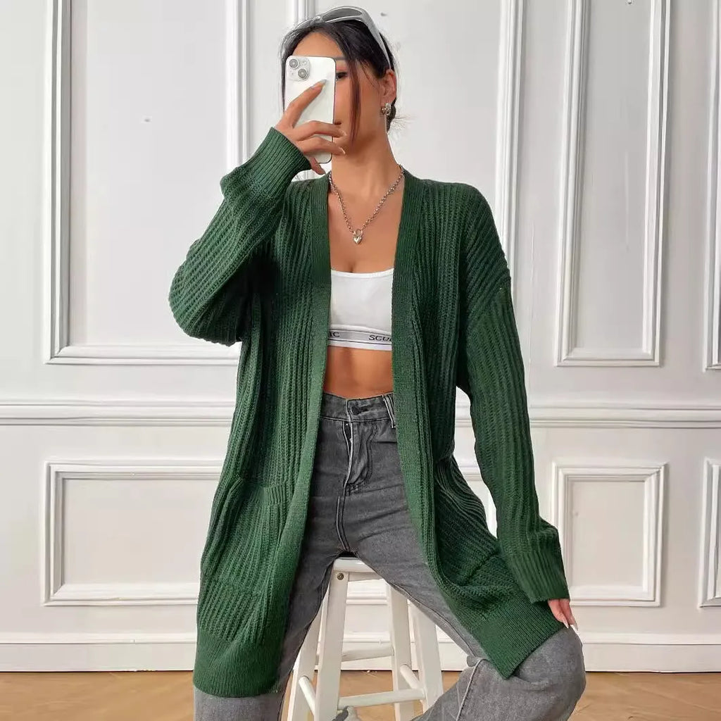 Women's dark green loose fit acrylic cardigan sweater with long sleeves on a hanger.