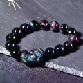Natural ice colour eye obsidian crystal bracelet on a wrist, showing polished beads.