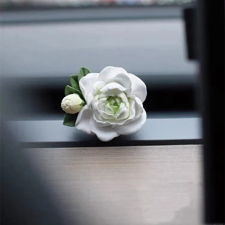 Jasmine scented gypsum solid car perfume clipped to a car air vent in off white or fresh green.
