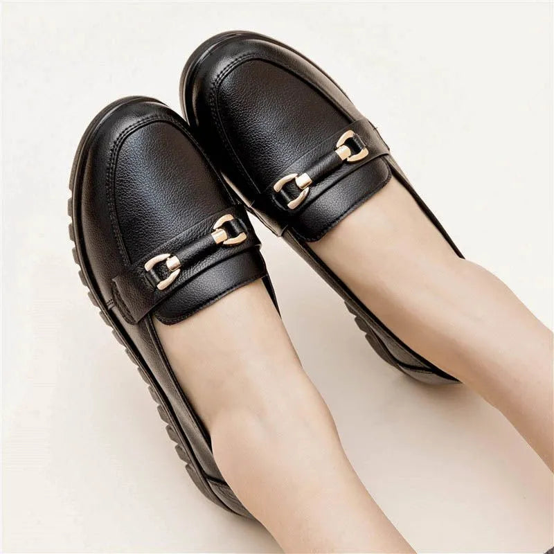 Black casual leather pumps with a soft rubber sole and low flat heel on a white background