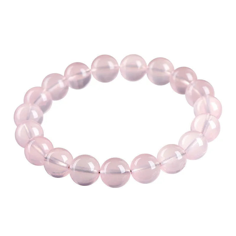 A pink crystal bead bracelet with polished round stones on a single strand.