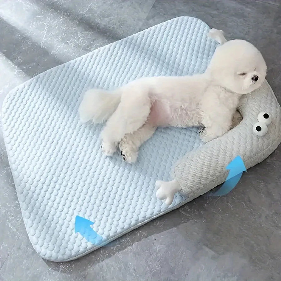 Blue pet bed cushion with big-eyed monster design for dogs and cats on a wooden floor.