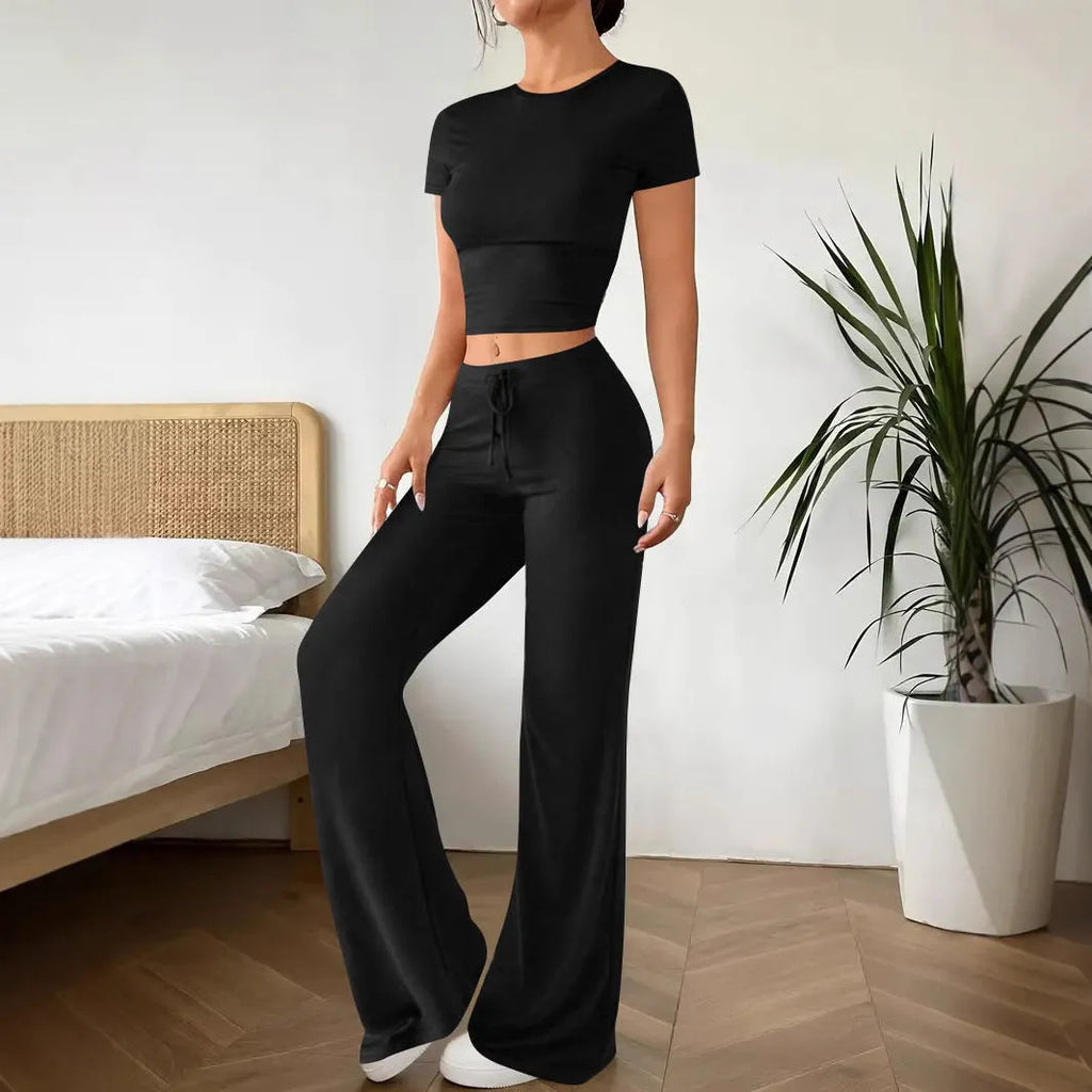 Women's black high waist trousers and regular sleeve t-shirt two-piece set laid flat.