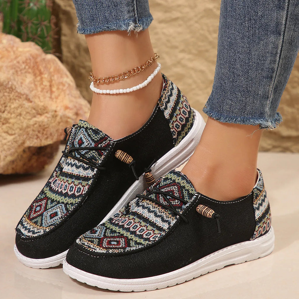 Women's black flat casual shoes with round toe and low-top design on a neutral background
