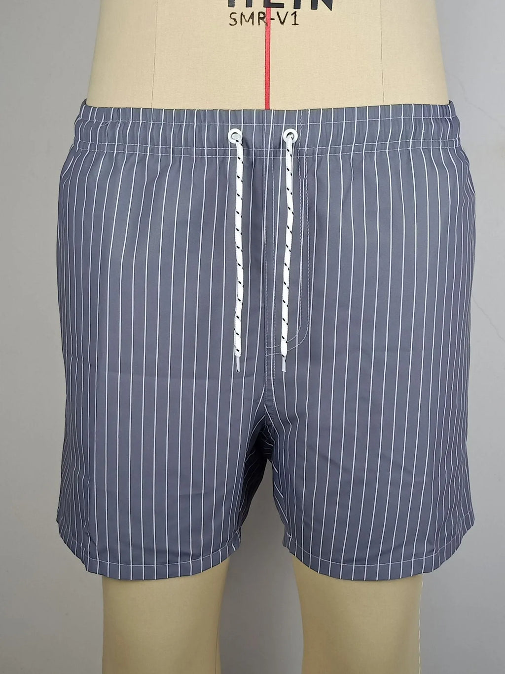 Men's striped polyester beach shorts in grey, shown with a straight leg fit and triangle lining detail.