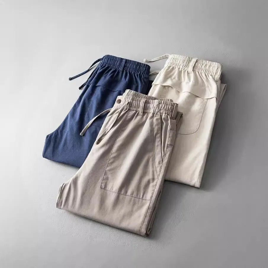 Men's linen casual trousers in a solid colour, shown in navy blue, apricot, and grey options.