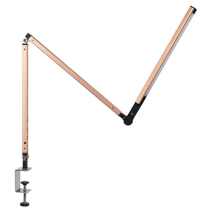 Black folding clip-on LED desk lamp with remote control on a wooden desk.