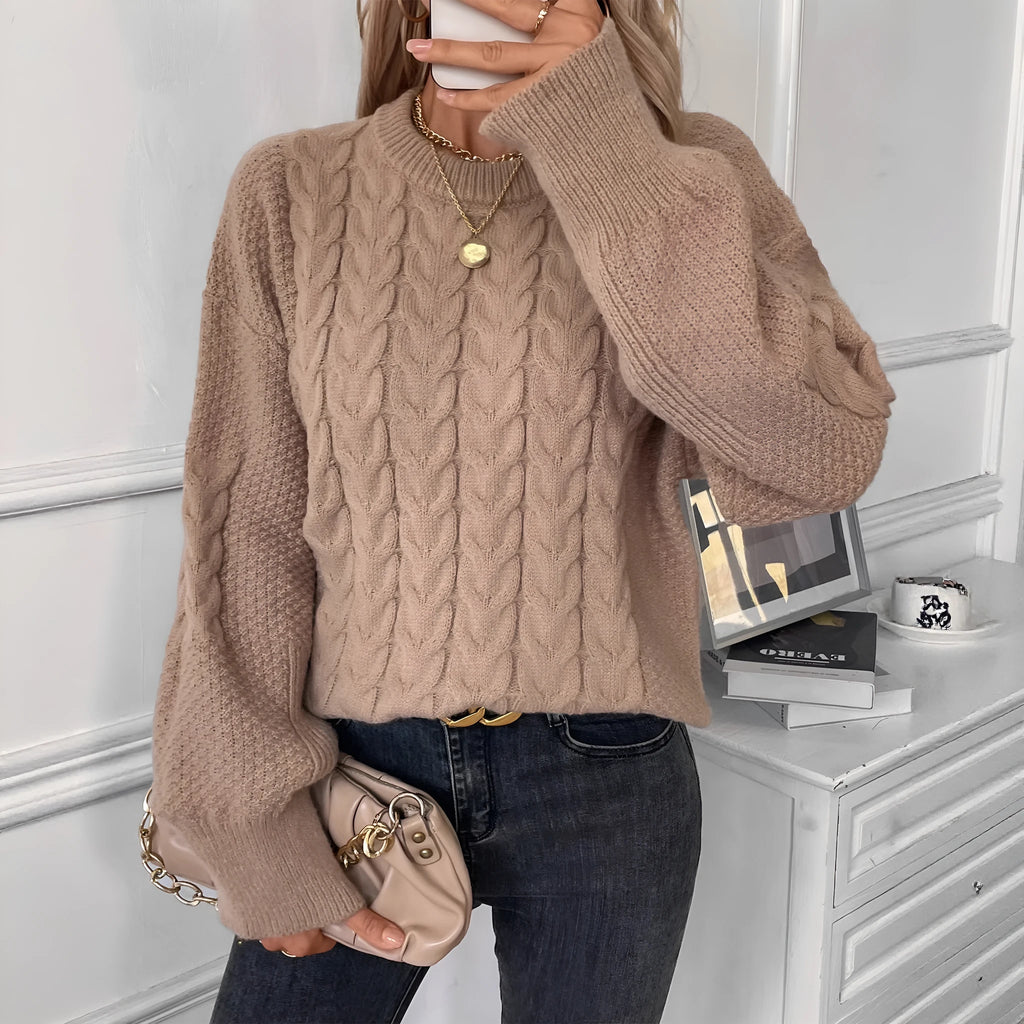 Women's beige loose-fitting sweater with twisted detailing on a hanger.