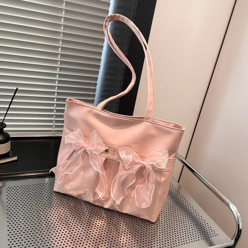 Black college style bow tote bag with double shoulder straps and large main compartment