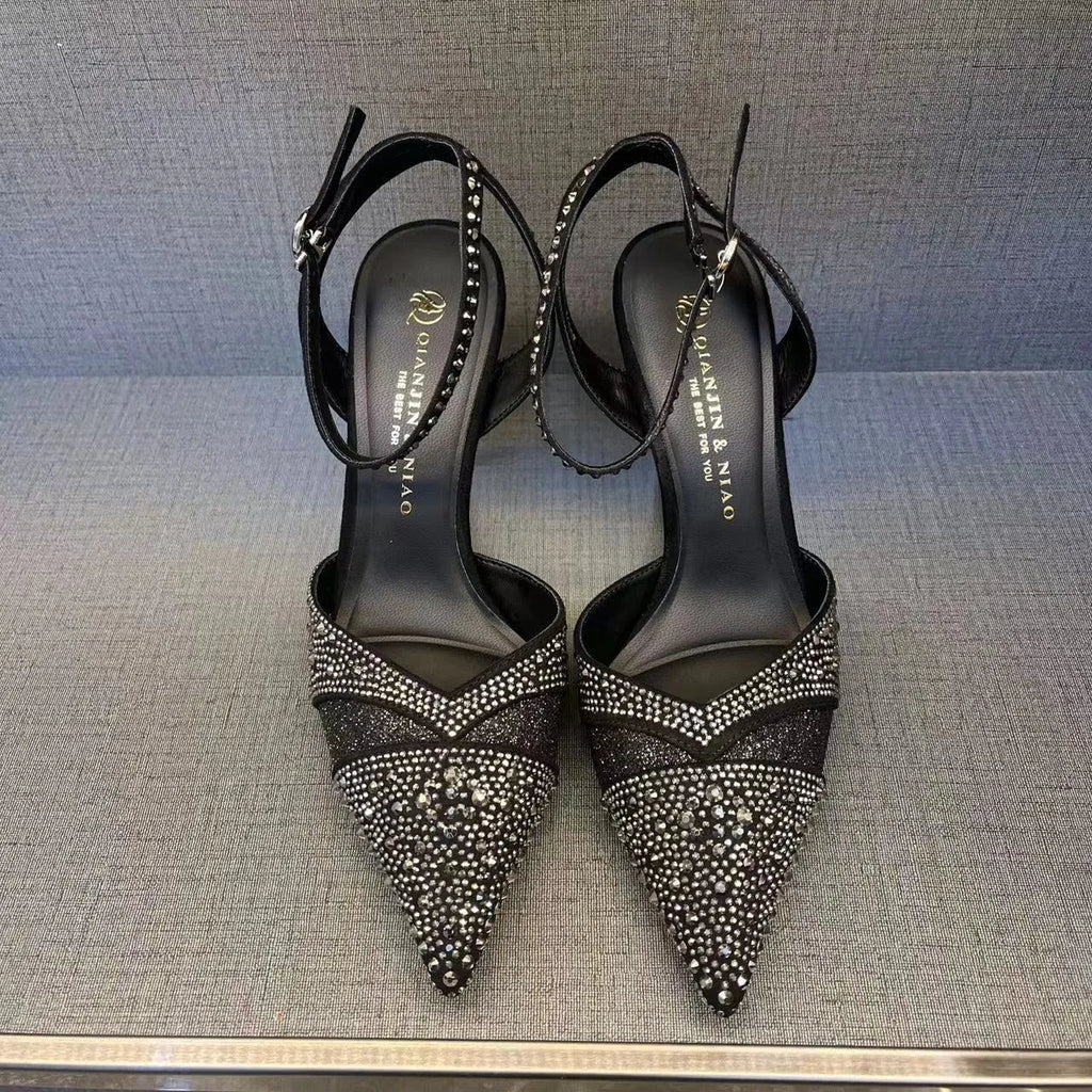 Women's silver hollow high heels with stiletto heel, pointed toe, and red sole on a plain background.