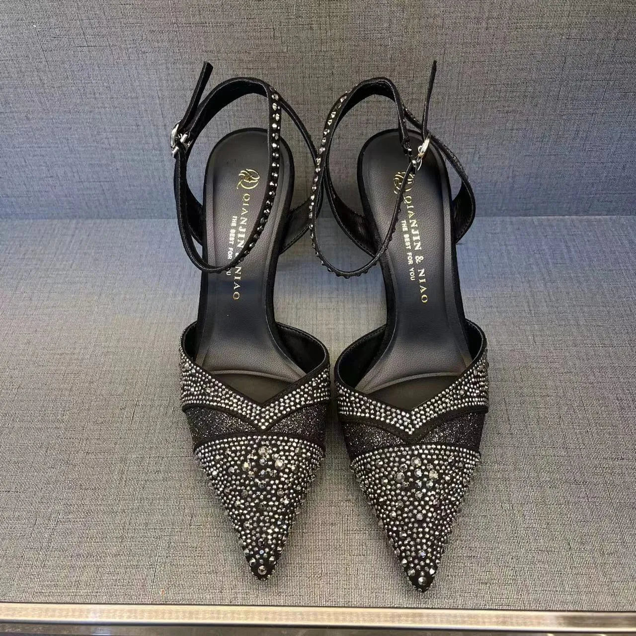 Women's silver hollow high heels with stiletto heel, pointed toe, and red sole on a plain background.