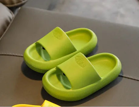 Children's bright coloured EVA slippers with textured non-slip soles, shown in blue, green, orange, pink, and yellow.