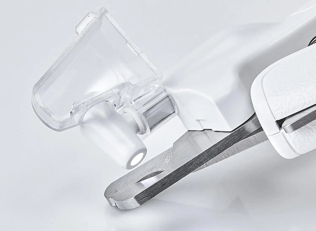 White pet nail clippers with LED light, transparent guard, and leather-like handle next to a nail file.