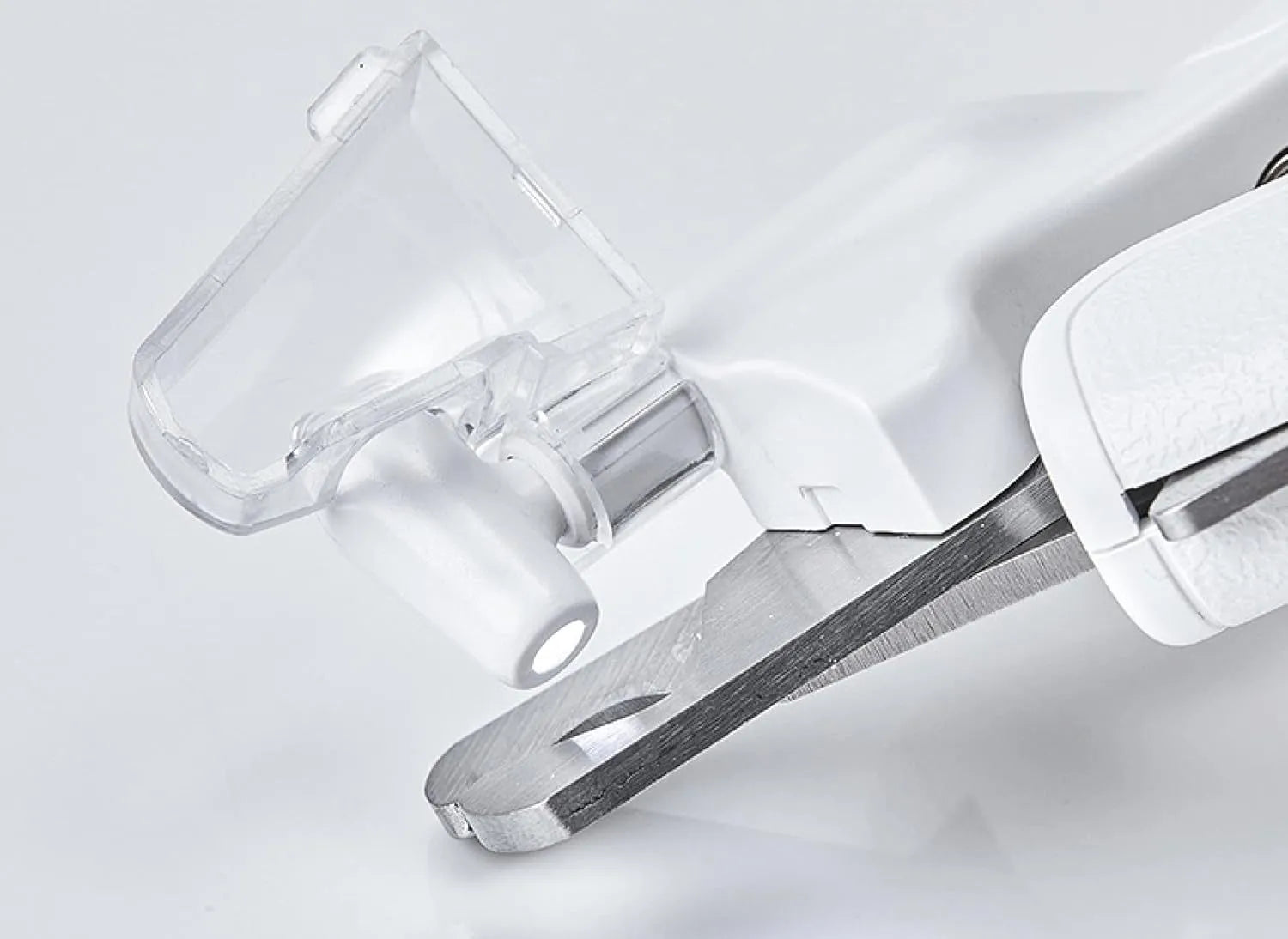 White pet nail clippers with LED light, transparent guard, and leather-like handle next to a nail file.