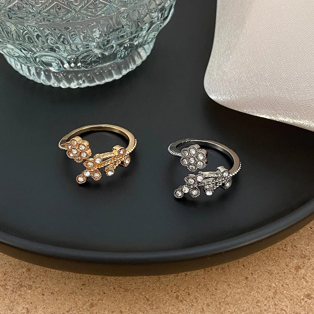Women's open ring with diamond-treated flower and leaf design in gold colour on copper base
