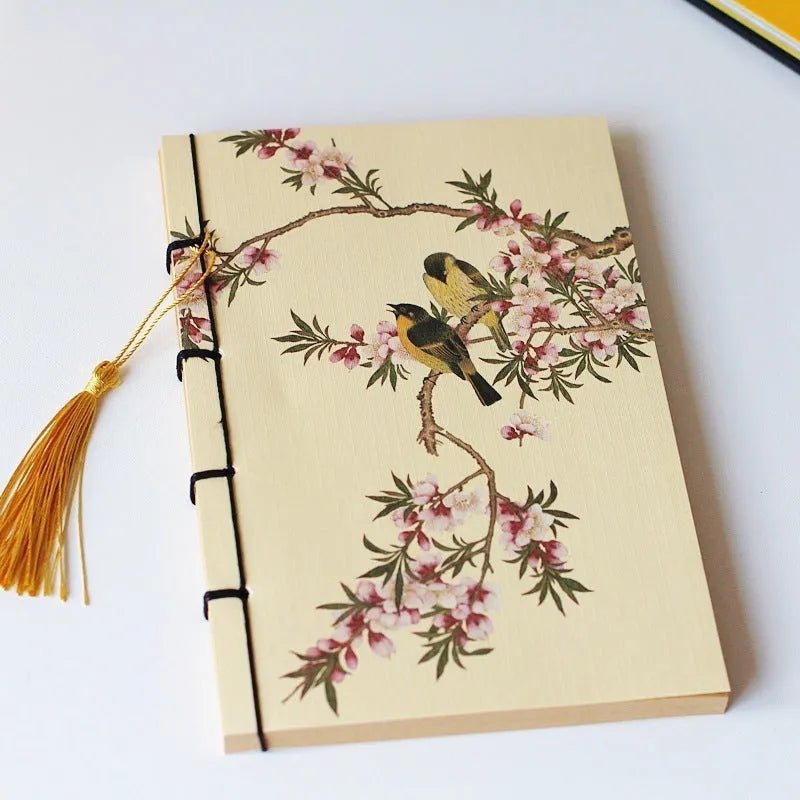 A5 antique wire-bound notebook with glossy embossed cover featuring a retro painting design, shown open.