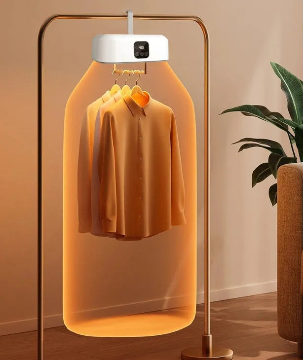 White cylindrical foldable clothes dryer with remote control on a table.