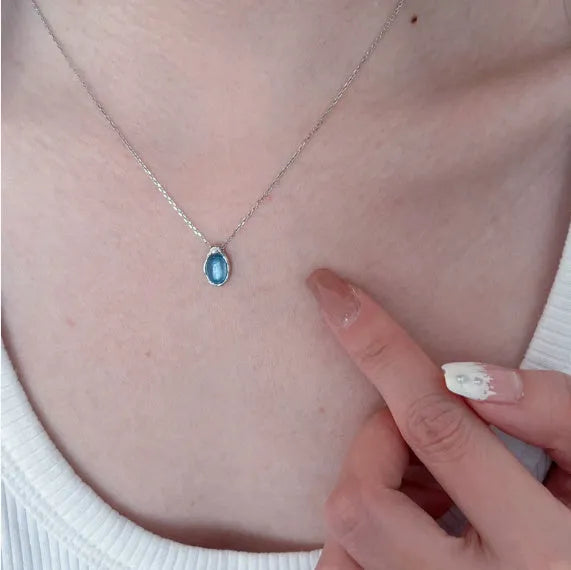 Navy blue and white gold geometric water drop pendant necklace on a cross chain for women.