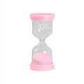Handmade glass sand timer hourglass in blue, green, pink or purple on a desk.
