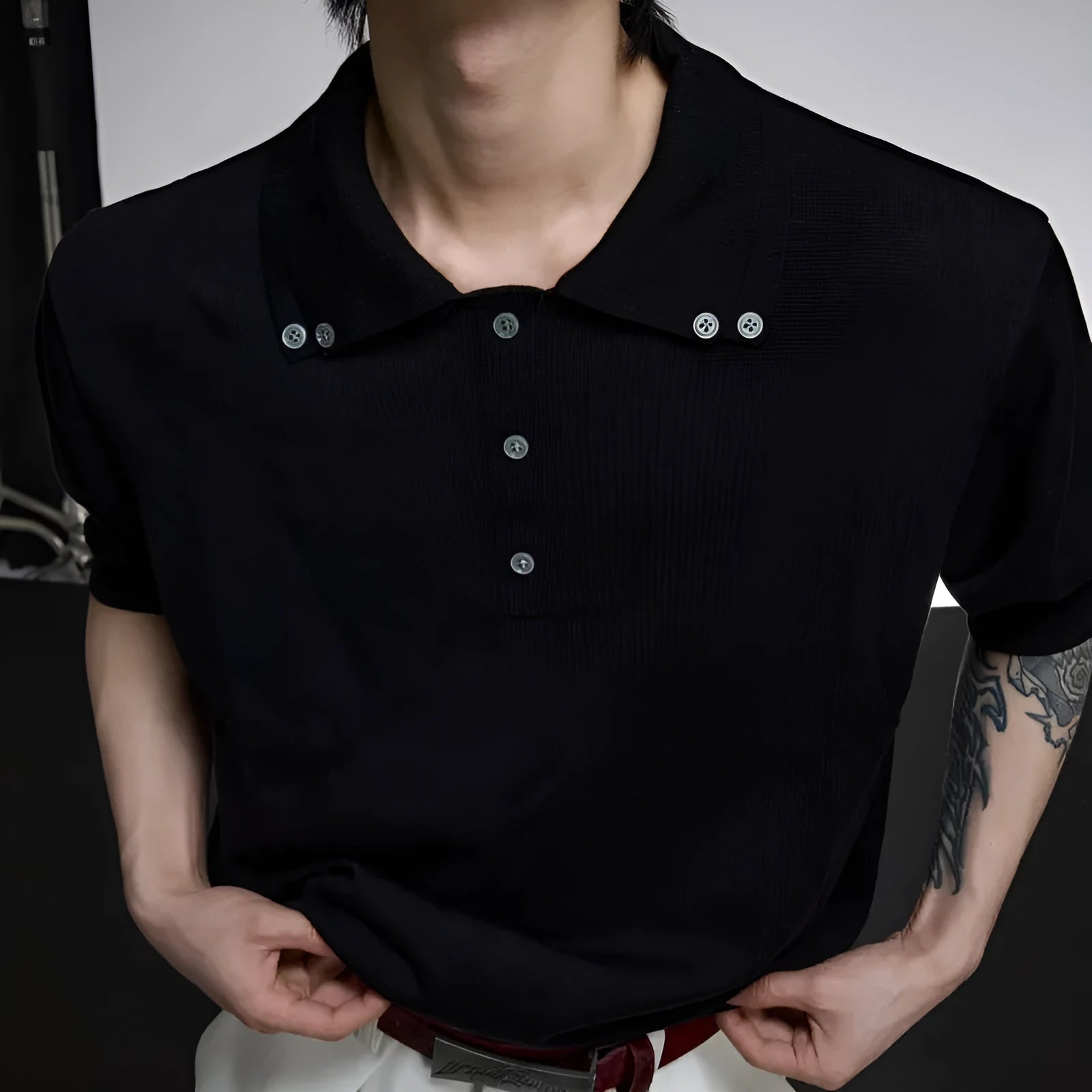 Man wearing a black loose-fit short sleeve shirt with a double lapel collar