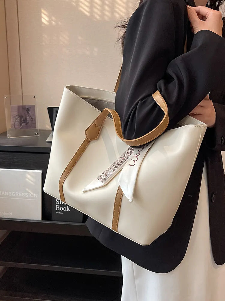 Large soft tote bag in bucket style with crossbody strap and sewing line detailing