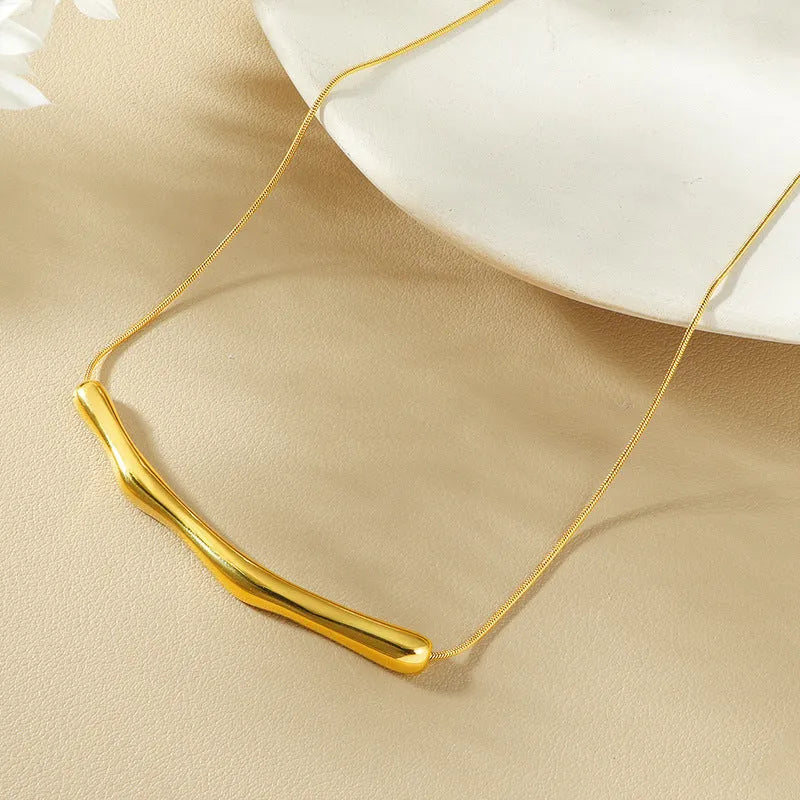 Close-up of a women's pleated titanium steel necklace in gold colour showing its textured folded design.