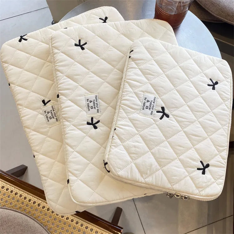 Nylon laptop storage bag with a rhombus-shaped embroidered bow on the front.