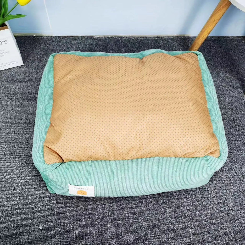 A light blue cotton dog nest with soft lining on a wooden floor.