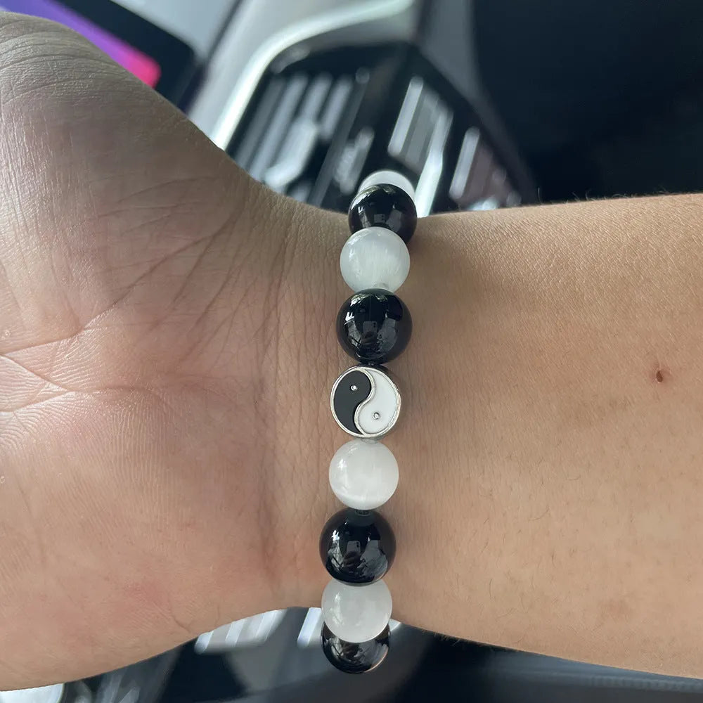 Close-up of a natural opal Tai Chi beaded bracelet with 10mm polished stones on a wrist.