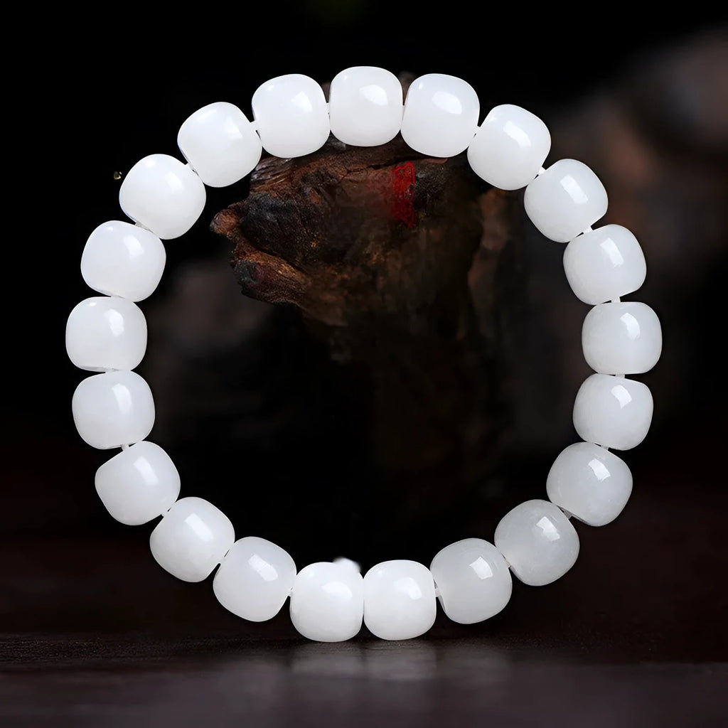 White Hetian jade barrel bead bracelet for men and women on a wrist.