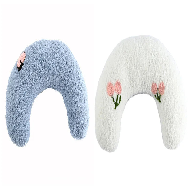 Small blue half-donut shaped pet pillow bed for cats or small dogs on a carpet.