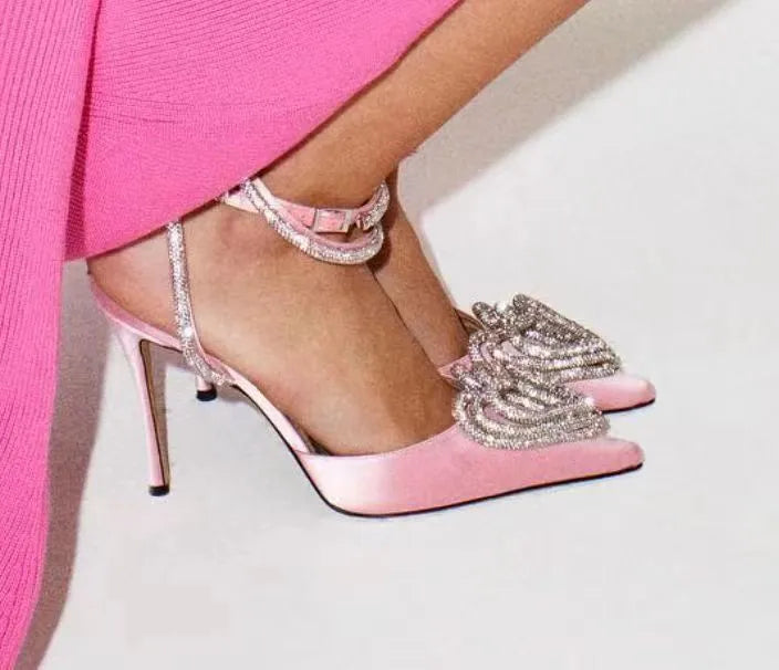 Women's pink satin sandal with heart-shaped rhinestone detail and adjustable ankle strap.