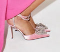 Women's pink satin sandal with heart-shaped rhinestone detail and adjustable ankle strap.