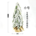 Small white 24-inch plastic Christmas tree with LED lights and simulated snow spray on desktop