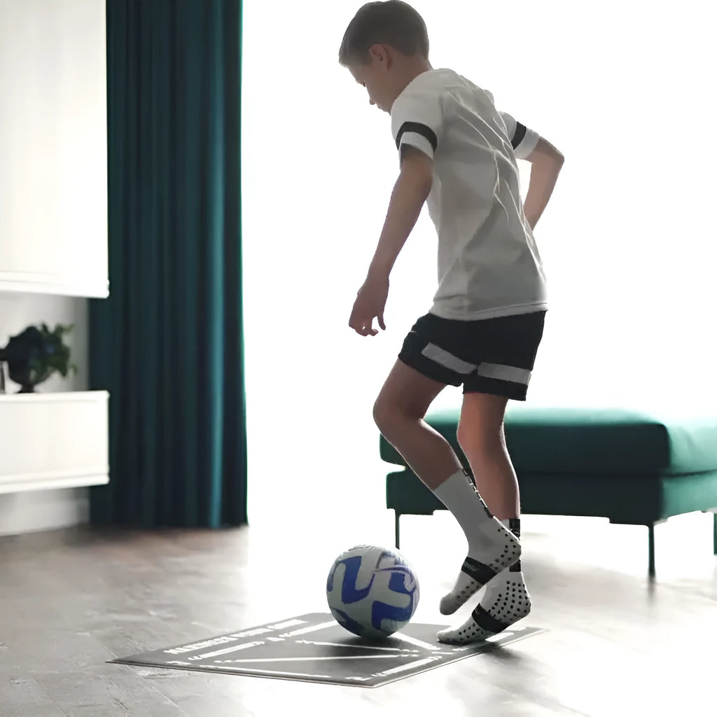 Black rectangular football training mat measuring 60 by 90 centimetres on a flat surface.